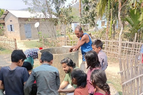 Dr Jagannath Biswakarma (in centre) helping children understand the groundwater quality in his hometown Assam, India.